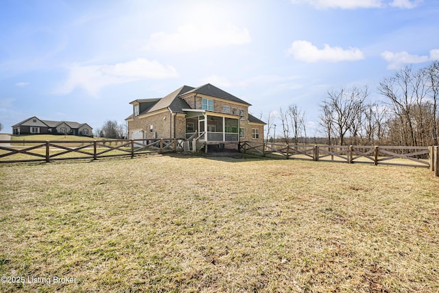 exterior space with a fenced backyard, brick siding, a sunroom, a gate, and a front yard