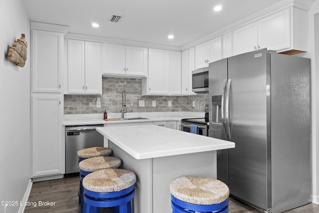 kitchen featuring visible vents, a sink, dark wood-style floors, white cabinetry, and appliances with stainless steel finishes