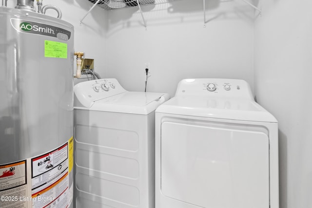 clothes washing area with laundry area, water heater, and washer and clothes dryer