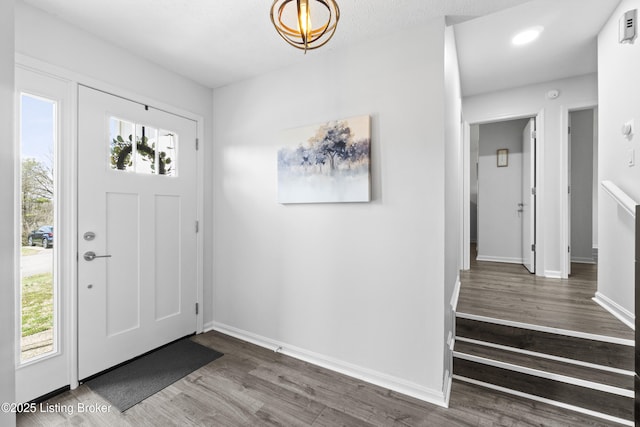 entrance foyer with baseboards and wood finished floors