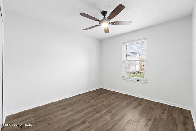 unfurnished room featuring dark wood-style floors, baseboards, and a ceiling fan