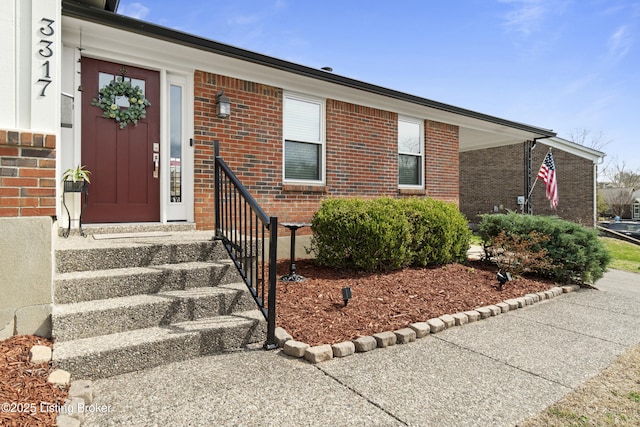 view of exterior entry featuring brick siding