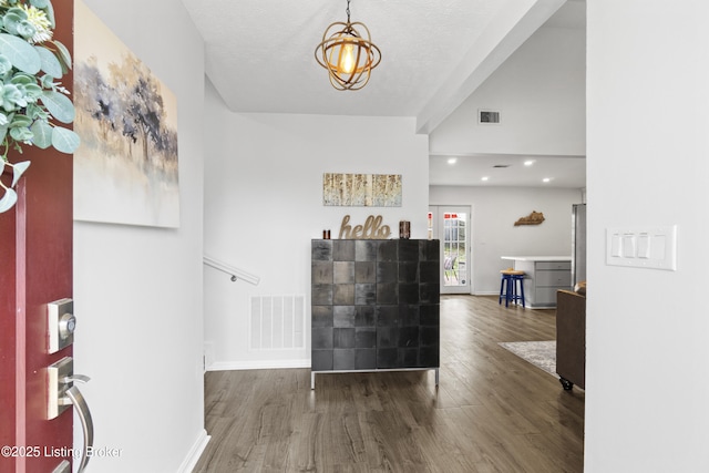 entryway featuring visible vents, an inviting chandelier, baseboards, and wood finished floors