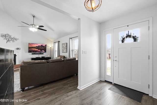 entrance foyer with wood finished floors, a healthy amount of sunlight, and vaulted ceiling