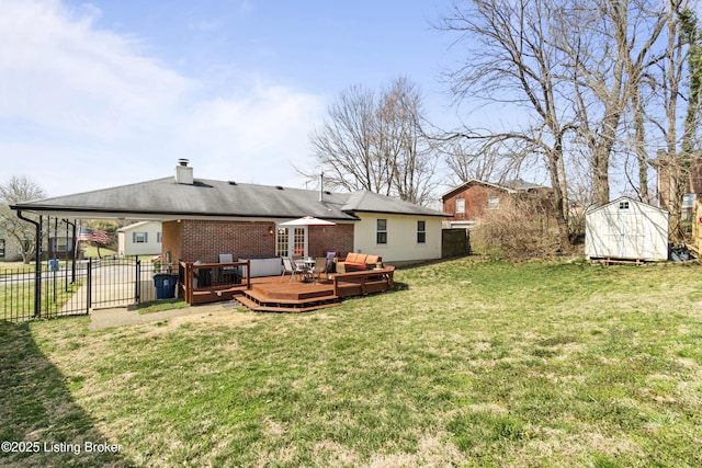 back of property with fence, a shed, a wooden deck, a lawn, and an outdoor structure