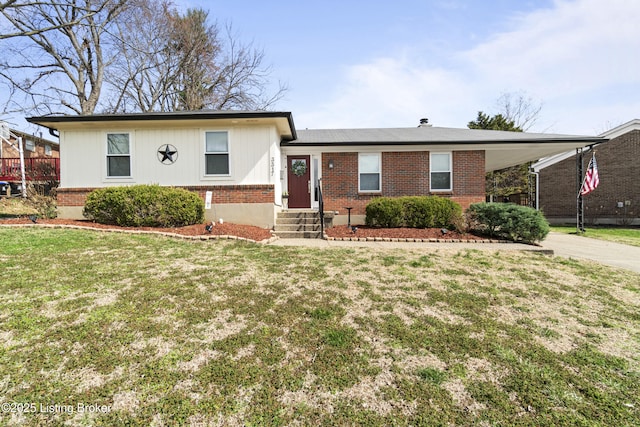 tri-level home with a front yard, driveway, entry steps, a carport, and brick siding