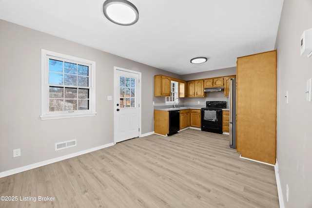 kitchen featuring under cabinet range hood, a sink, visible vents, light countertops, and black appliances