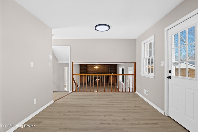 entrance foyer featuring visible vents, baseboards, and wood finished floors