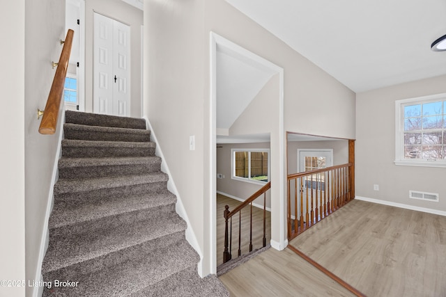 staircase featuring visible vents, baseboards, and wood finished floors