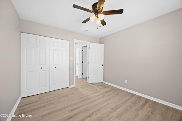 unfurnished bedroom with light wood-style flooring, baseboards, and a closet