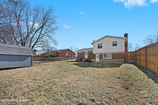 view of yard with an outbuilding, a fenced backyard, and a storage shed