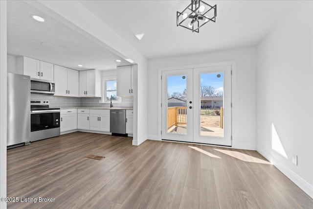 kitchen featuring dark wood finished floors, backsplash, stainless steel appliances, and light countertops