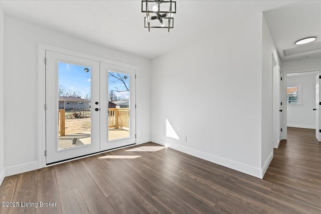 unfurnished dining area featuring french doors, baseboards, and dark wood-type flooring