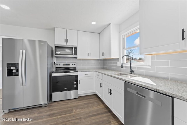 kitchen with tasteful backsplash, dark wood finished floors, stainless steel appliances, and a sink