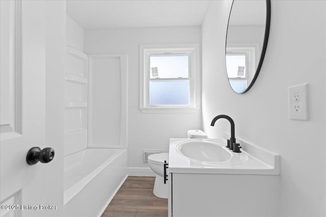 bathroom featuring vanity, wood finished floors, visible vents, baseboards, and toilet