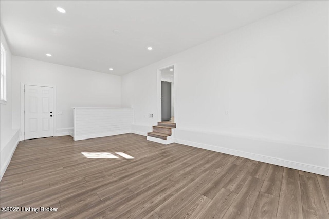 spare room featuring recessed lighting, wood finished floors, and baseboards