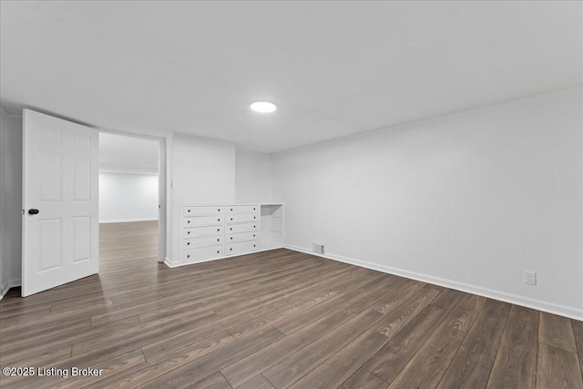 unfurnished room featuring visible vents, baseboards, and wood finished floors