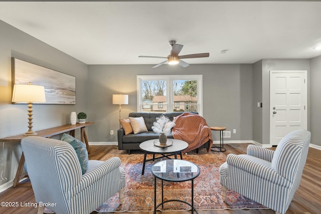 living room with wood finished floors, a ceiling fan, and baseboards