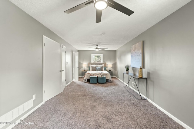 unfurnished bedroom with a ceiling fan, a textured ceiling, baseboards, and carpet flooring