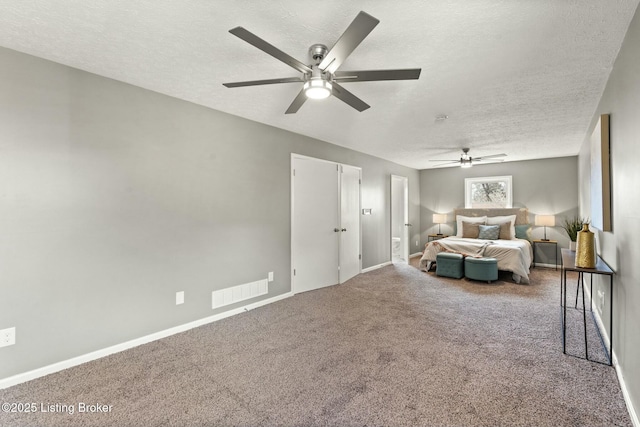 bedroom featuring a textured ceiling, carpet floors, visible vents, and a ceiling fan