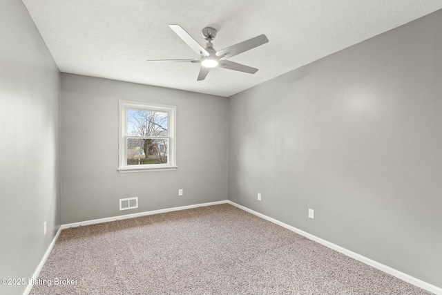 carpeted empty room with visible vents, a textured ceiling, and baseboards