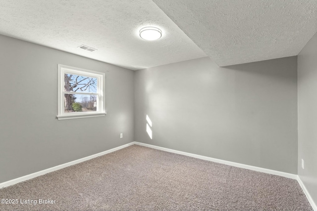 carpeted empty room with a textured ceiling, visible vents, and baseboards