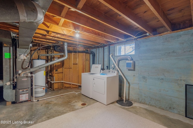 basement featuring washer and dryer, water heater, and heating unit