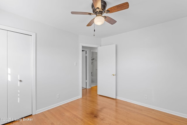 unfurnished bedroom featuring a closet, ceiling fan, light wood-style flooring, and baseboards