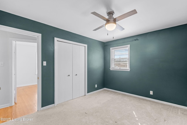 unfurnished bedroom featuring ceiling fan, a closet, carpet flooring, and baseboards