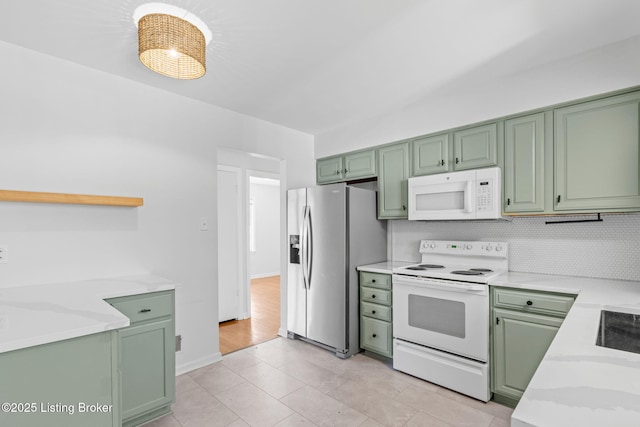 kitchen with white appliances, open shelves, and green cabinetry