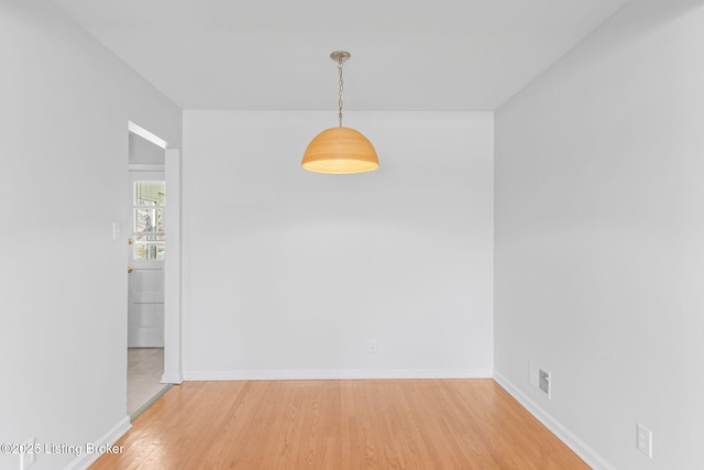 unfurnished dining area featuring light wood-style flooring and baseboards