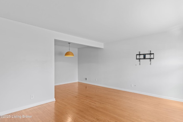 unfurnished room featuring light wood-type flooring and baseboards