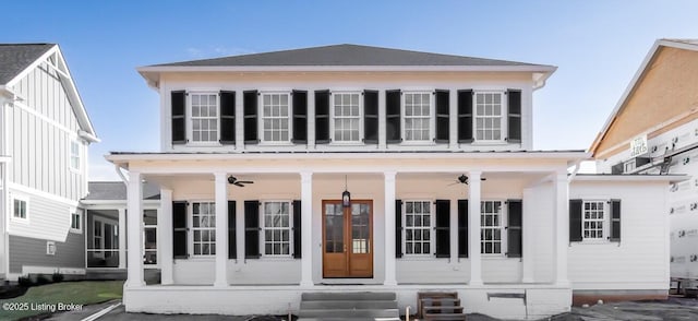 view of front of home with a ceiling fan, entry steps, a sunroom, and roof with shingles