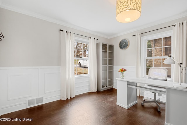 office space featuring dark wood-type flooring, wainscoting, visible vents, and ornamental molding