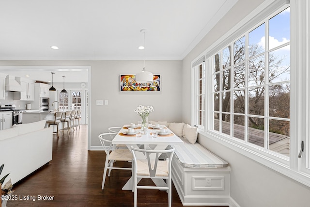 dining space featuring baseboards, dark wood-type flooring, breakfast area, and crown molding