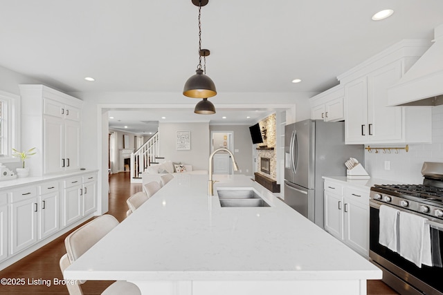 kitchen with stainless steel appliances, dark wood-type flooring, a sink, white cabinets, and custom exhaust hood