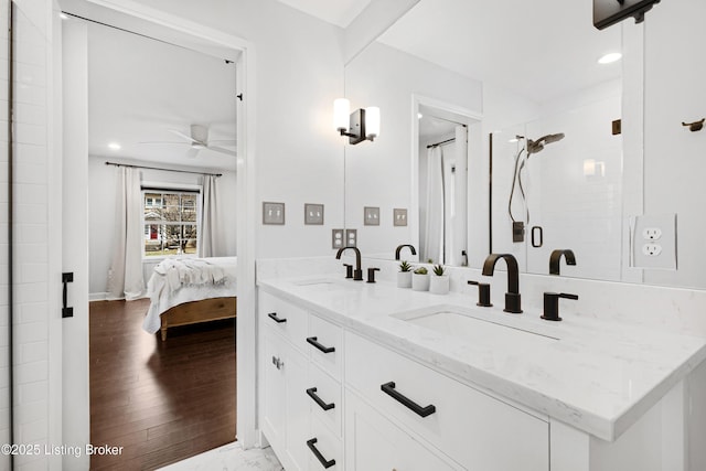 ensuite bathroom with a stall shower, a sink, ensuite bathroom, and ceiling fan