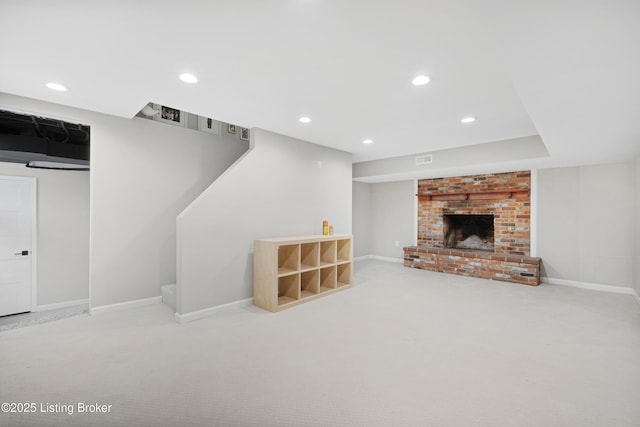 interior space with a brick fireplace, carpet, and recessed lighting