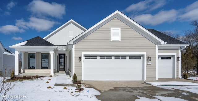 view of front of house featuring a garage, a shingled roof, and driveway