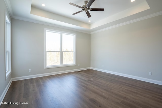 empty room with ceiling fan, recessed lighting, dark wood finished floors, baseboards, and a raised ceiling