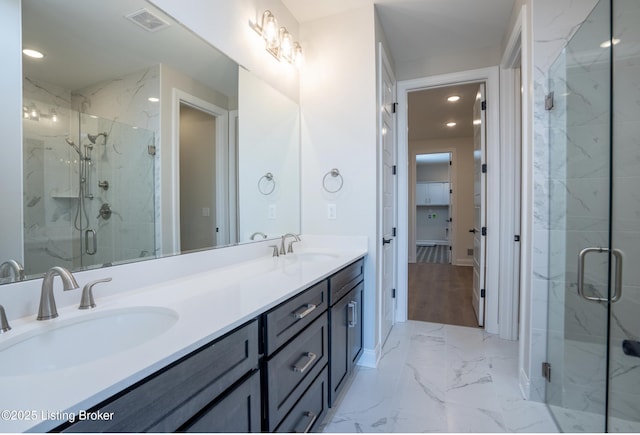 full bathroom featuring marble finish floor, a marble finish shower, a sink, and visible vents