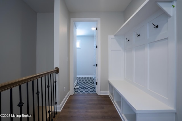 mudroom with dark wood-style floors and baseboards