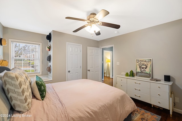 bedroom featuring baseboards, a ceiling fan, and dark wood-type flooring