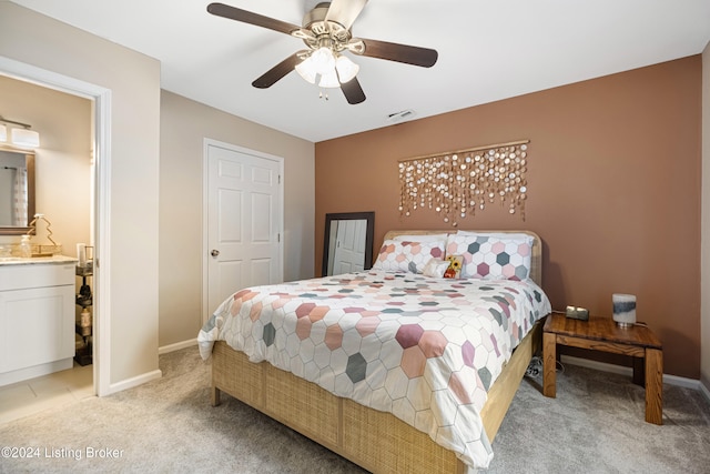 bedroom featuring connected bathroom, light carpet, a ceiling fan, visible vents, and baseboards