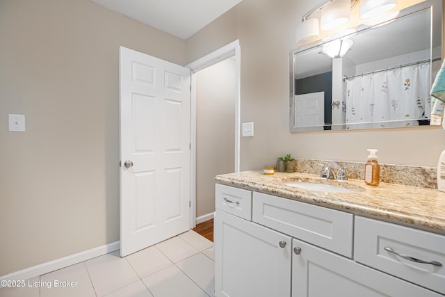 full bath featuring baseboards, vanity, and tile patterned floors