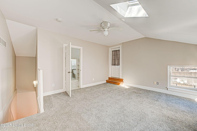 bonus room featuring vaulted ceiling with skylight, visible vents, baseboards, a ceiling fan, and carpet floors