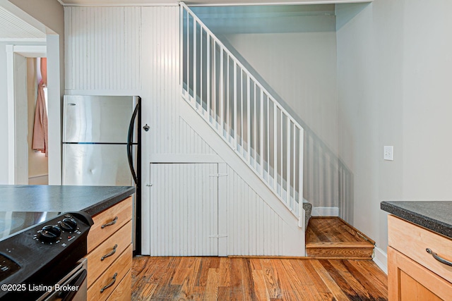 kitchen featuring range with electric cooktop, dark countertops, and wood finished floors