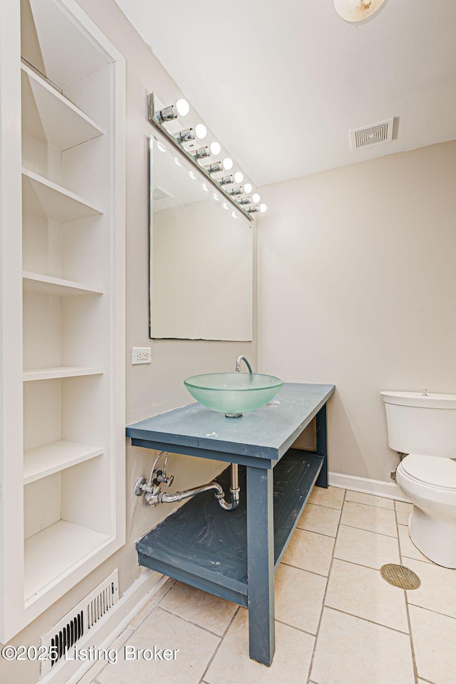 bathroom with built in shelves, tile patterned flooring, visible vents, and toilet