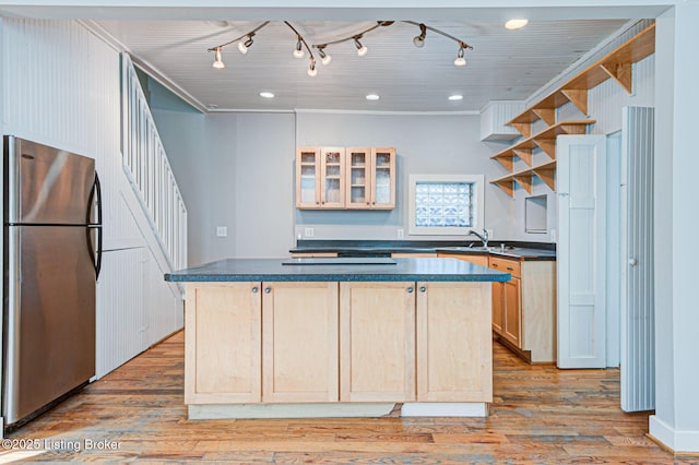 kitchen featuring light wood-style floors, light brown cabinetry, freestanding refrigerator, open shelves, and dark countertops