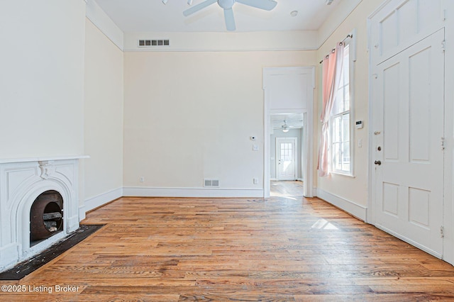 unfurnished living room featuring visible vents, ceiling fan, and wood finished floors